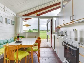 Enjoy meals with a view of the surrounding landscape from this kitchen's large window.