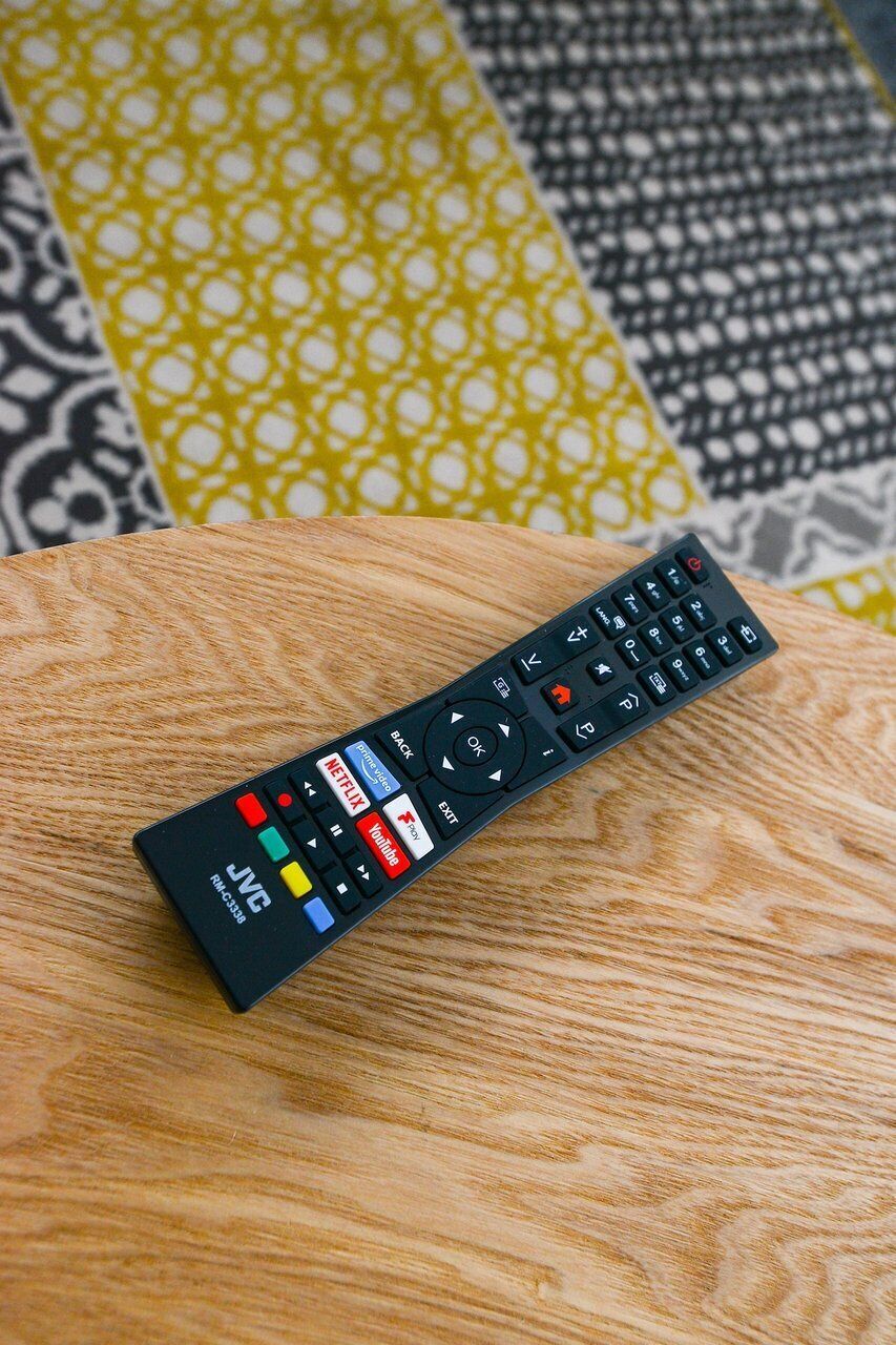 A remote control on a wooden surface.