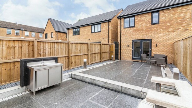A patio area with a built-in sink and seating, surrounded by a wooden fence and a brick building. - A Stylish, essential 3bed Home with Secure Parking (Nottingham)