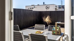 An outdoor seating area with a table, chairs, and a bottle of beer.