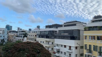 Un edificio moderno en la ciudad con varios pisos, balcones y una mezcla de estilos arquitectónicos.