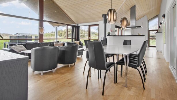 Ein modernes Interieur mit Essbereich, Sofas und einer Küche.
