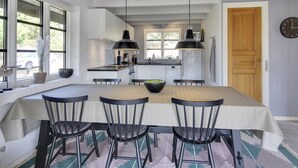 A modern kitchen with a central island, pendant lights, and a dining area with chairs. - "Grita" - 500m from the sea by Interhome (Vejers Strand)