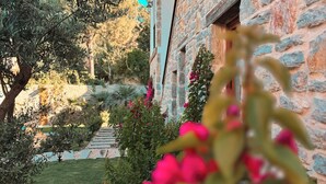A stone building with a garden and a clear blue sky. - Dilek Hanım Konağı Datça (Datça)