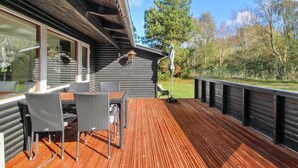 A wooden deck with outdoor furniture, a pergola, and a view of the surrounding trees. - "Herly" - 50m from the sea by Interhome (Hals)
