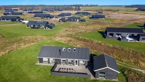 A modern residential area with multiple houses featuring dark roofs and large windows.