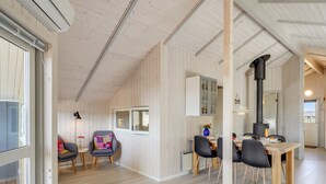 A cozy cabin interior with a dining area, a fireplace, and a view through a window. - "Estella" - 500m to the fjord by Interhome (Hvide Sande)