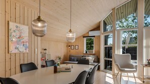 Een moderne keuken met een ronde eettafel, zwarte stoelen en hanglampen.