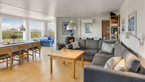 Ein modernes Wohnzimmer mit einer Couch, einem Esstisch und einem Kamin.