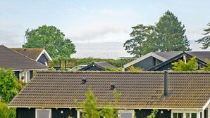 A row of small, dark-colored cabins with sloped roofs, likely part of a campground or vacation rental.