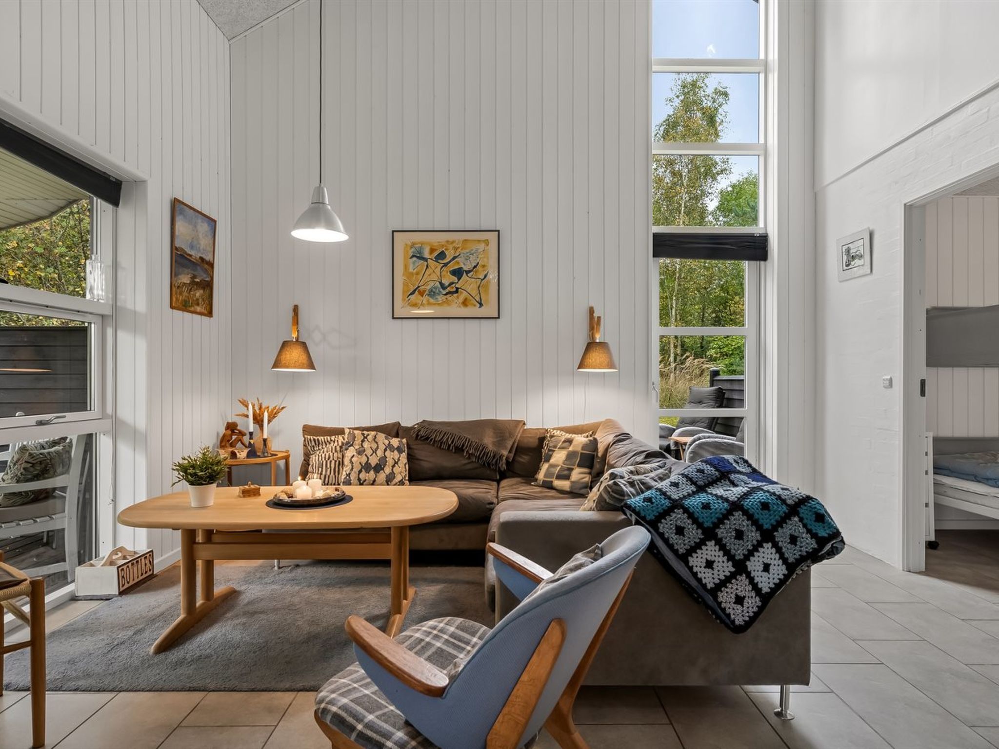 Un salon moderne avec un canapé, des fauteuils, une table basse et des œuvres d’art accrochées aux murs.