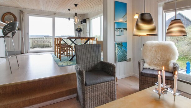 A cozy room with wicker furniture, a wooden ceiling, and a view of the outdoors.