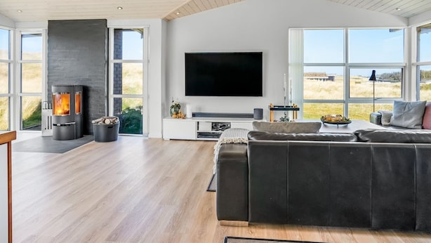A modern living room with a fireplace, a large flat-screen TV, and a sofa. - "Ingela" - 350m from the sea by Interhome (Løkken)