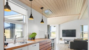 A modern kitchen with a wooden countertop, white cabinetry, and pendant lighting. - "Ingela" - 350m from the sea by Interhome (Løkken)