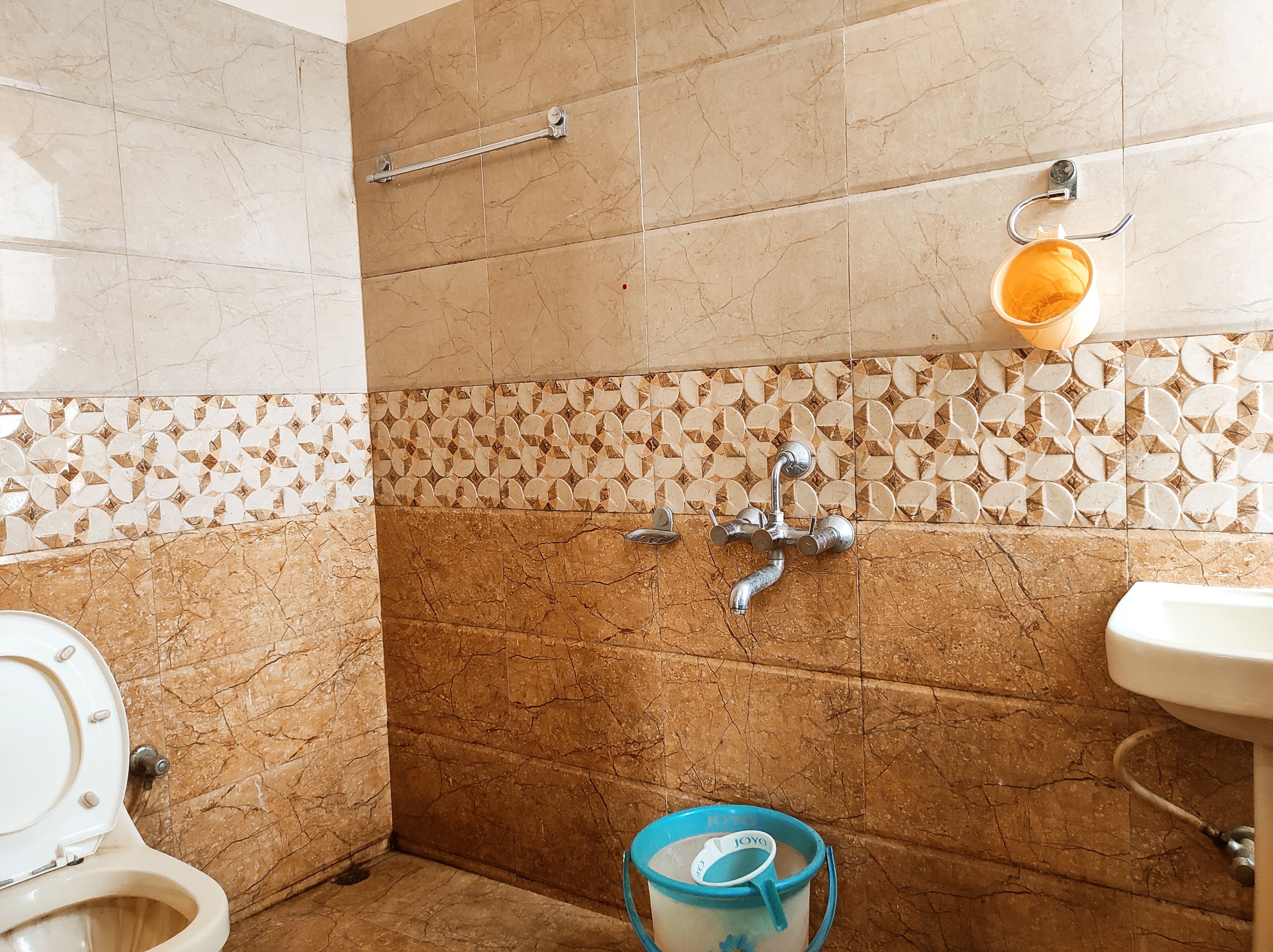 Une salle de bain comprenant des toilettes, un lavabo et un espace douche.
