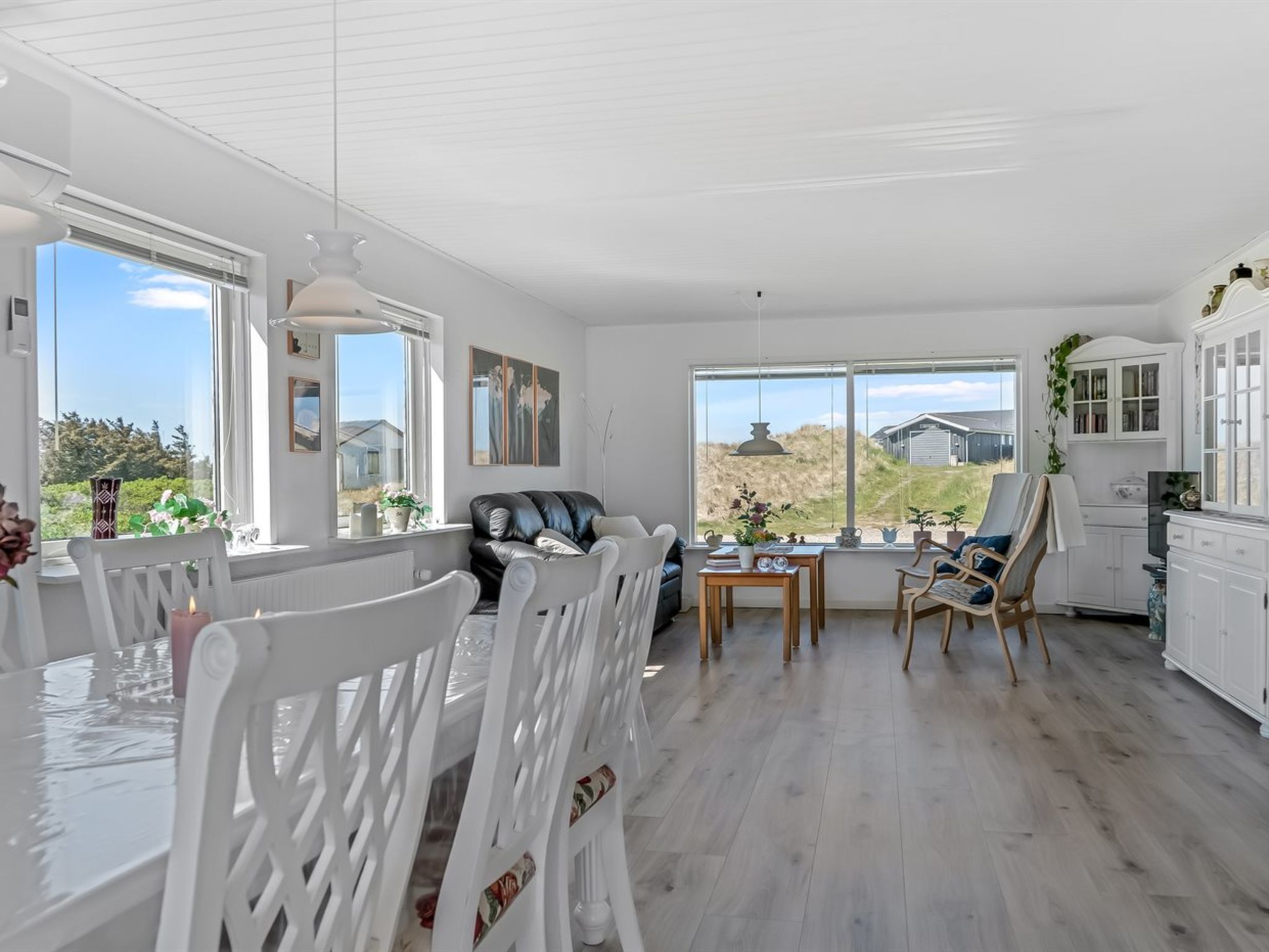 A spacious room with a dining area, a sofa, and a view of the outdoors.