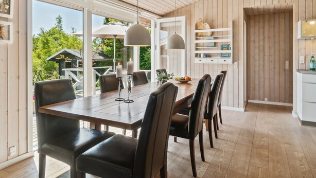 A modern dining area with a wooden table, black chairs, and pendant lights. - "Gerhild" - 300m from the sea by Interhome (Ebeltoft)