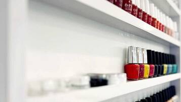 Uma parede com várias embalagens de esmalte organizadas, em diversas cores.