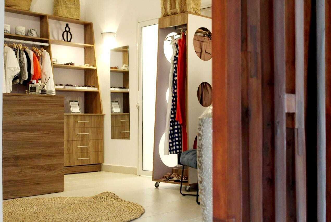 A walk-in closet with wooden shelving, a shoe rack, and a mirrored closet door.