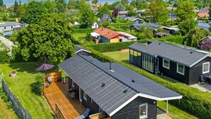 Een woongebied met huizen, een houten terras en uitzicht op zee.