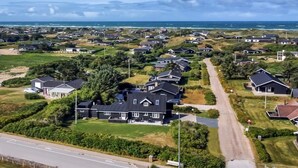 Zona residencial amb cases, carreteres i vistes al mar.