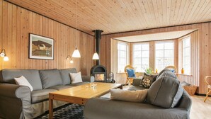 Ein gemütliches Wohnzimmer mit Sofa, Sessel und Kamin.