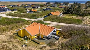 A coastal residential area with houses featuring red roofs and a yellow building with a deck. - "Midja" - 800m from the sea by Interhome (Hvide Sande)