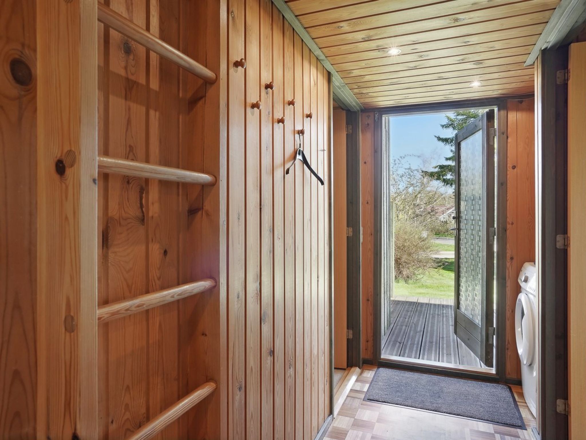 A wooden interior with a sliding glass door leading to an outdoor area.