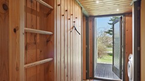 A wooden interior with a sliding glass door leading to an outdoor area.