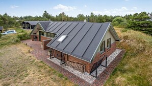 A modern, two-story house with a sloped roof, a brick exterior, and a paved driveway. - "Görel" - 1km from the sea by Interhome (Blåvand)