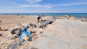 A beach with large rocks and a clear sky.