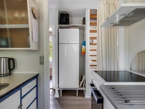 A compact kitchen with a refrigerator, a coffee maker, and a microwave.
