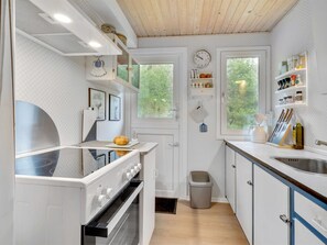 Een koelkast, een microgolfoven, kookgerei, borden en bestek