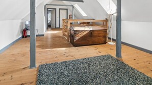 A loft bedroom with a sloped ceiling, wooden floor, and a large trunk as a bed. - "Myra" - 18km from the sea by Interhome (Bredebro)