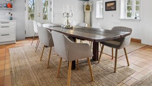 A dining room with a large wooden table, four chairs, a chandelier, and a clock on the wall. - "Myra" - 18km from the sea by Interhome (Bredebro)