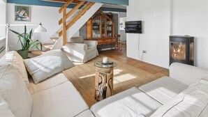 A living room with a sofa, a coffee table, a fireplace, a television, and a staircase. - "Myra" - 18km from the sea by Interhome (Bredebro)