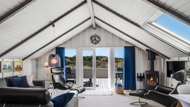 A spacious living area with a high ceiling, a fireplace, and a view of the outdoors. - "Halda" - 300m from the sea by Interhome (Vejers Strand)