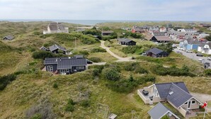 An aerial view of a coastal village with houses surrounded by grassy terrain and dunes. - "Halda" - 300m from the sea by Interhome (Vejers Strand)