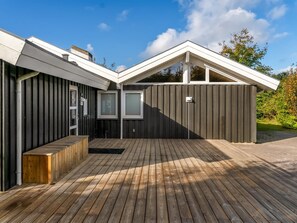 A modern house with a wooden deck, a sloped roof, and a fenced backyard. - "Mechthild" - 2.7km from the sea by Interhome (Saltum)
