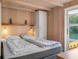 A bedroom with a bed, a wardrobe, and a window with a view of greenery. - "Mechthild" - 2.7km from the sea by Interhome (Saltum)