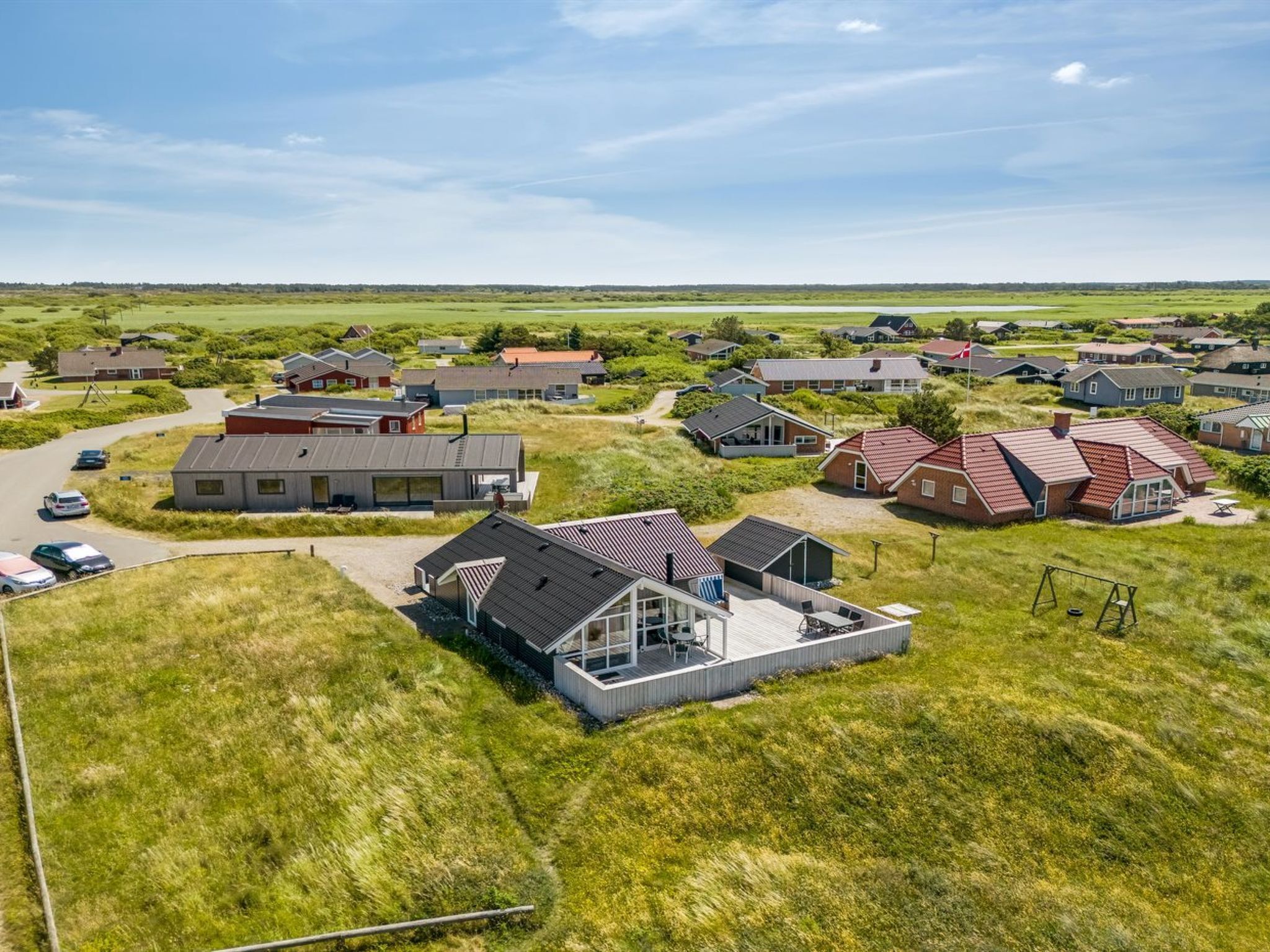 Et boligområde med huse, veje og en græsplæne.