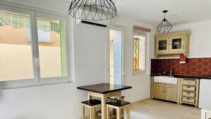 A modern kitchen with wooden cabinets, a dining table, and a pendant light.
