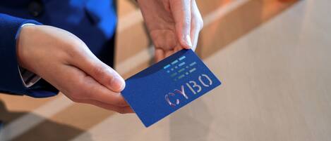 A person holding a blue card with the text "CYBO" on it.
