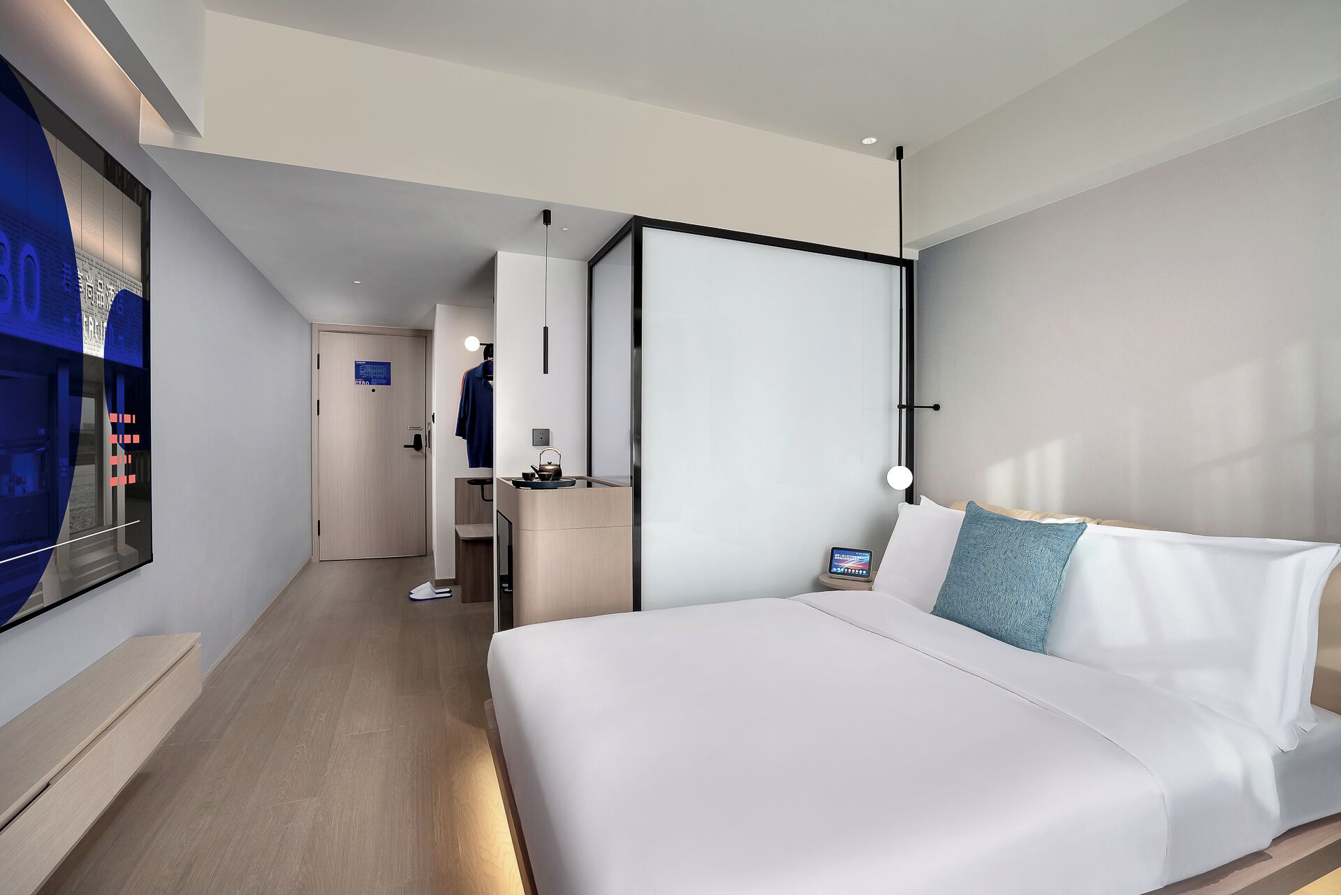 A modern hotel room with a large bed, a desk, and a television.