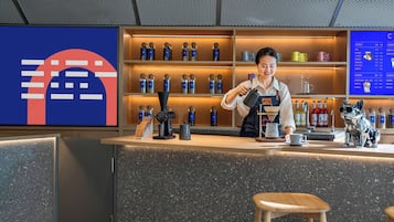 A bar area with a counter, shelves with bottles, and a menu board.