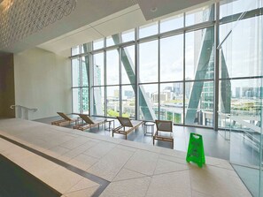 Relax in a spacious seating area with floor-to-ceiling windows offering city views.