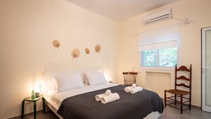A bedroom with a bed, a nightstand, a chair, and decorative wall art. - Eclectic Rabin Square Apt by Sea N' Rent (Tel Aviv)
