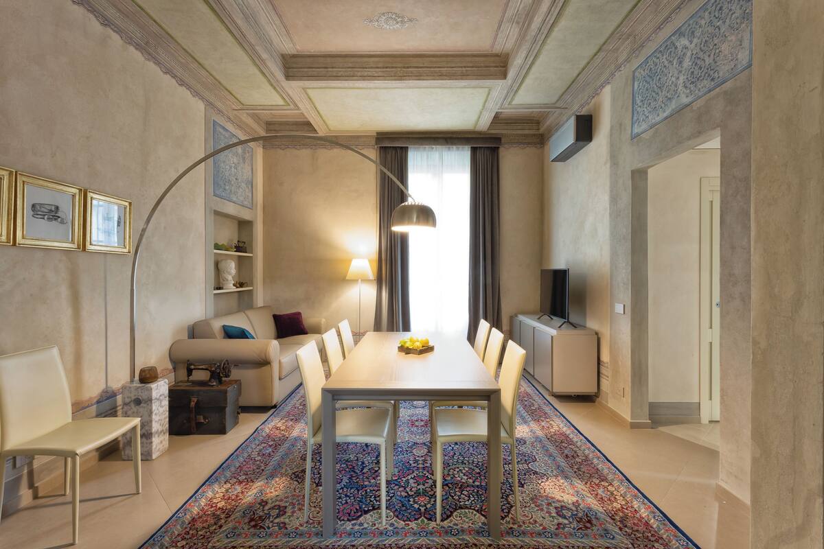 A modern living room with a dining table, sofa, and TV.