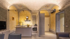 A modern kitchen with an island, built-in oven, and a flat-screen TV. - Casa del Sarto (Florence)