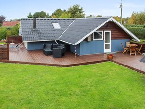 A modern house with a sloped roof, a deck with outdoor furniture, and a well-maintained lawn. - "Jyde" - 1.5km from the sea by Interhome (Hals)